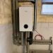 Bosch Inneneinheit im Keller, angeschlossen an isolierte Heizungsrohre und Steuerleitungen.