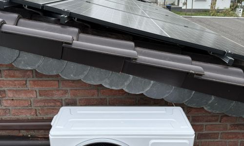 Bosch Klima Außengerät auf Flachdach, davor geneigte Solarmodule auf Ziegeldach.