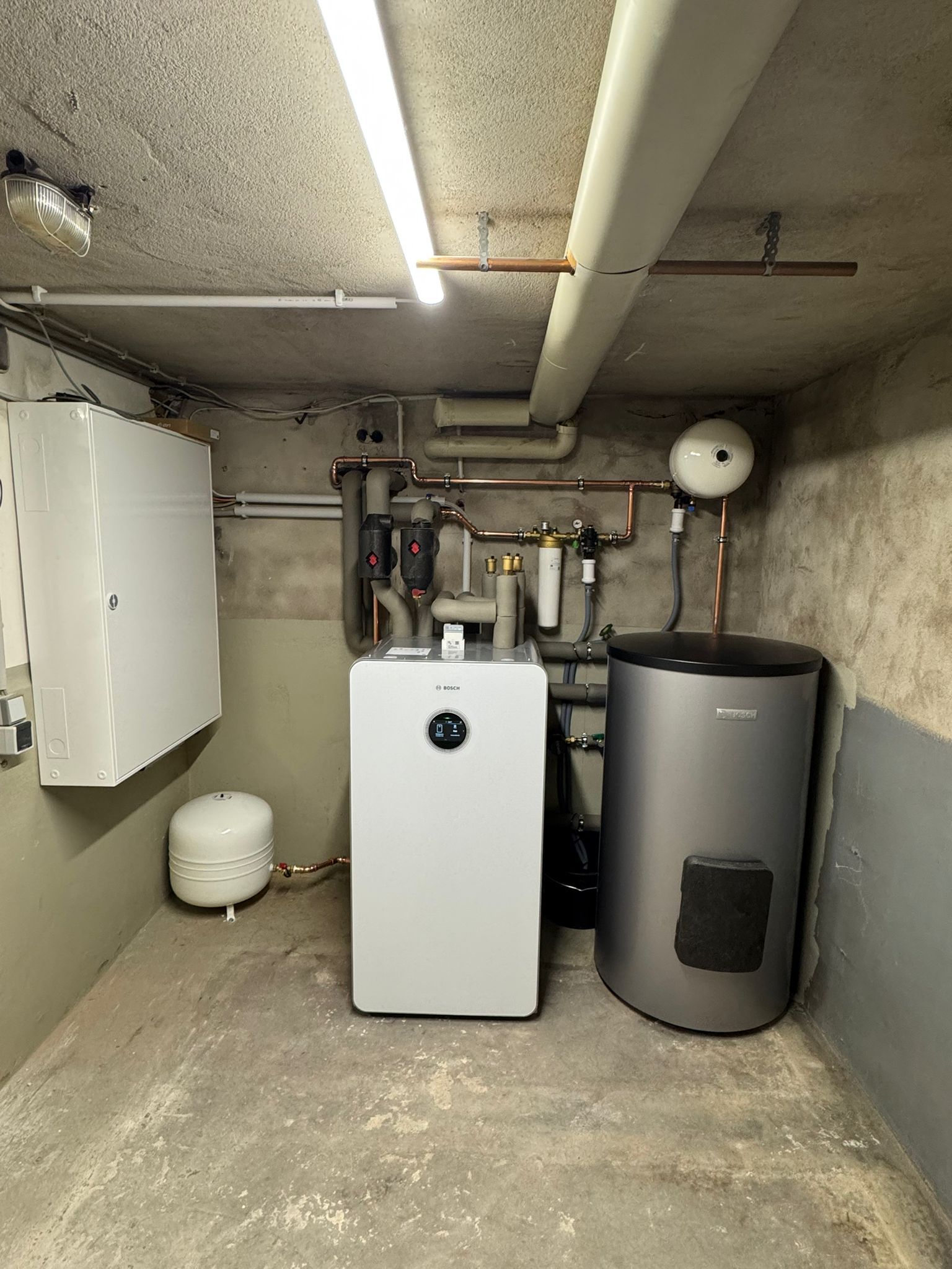 Kellerraum mit Ecodan Inneneinheit, Ausdehnungsgefäß und gedämmten Heizungsrohren.