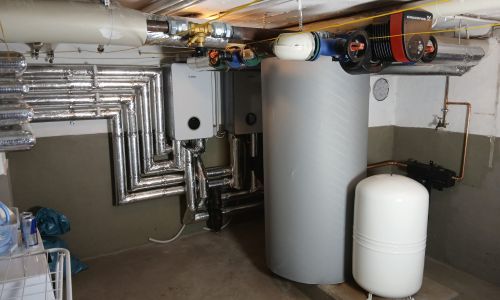 Kellerraum mit Pufferspeicher, Bosch Inneneinheiten, Pumpen und gedämmten Heizungsleitungen.