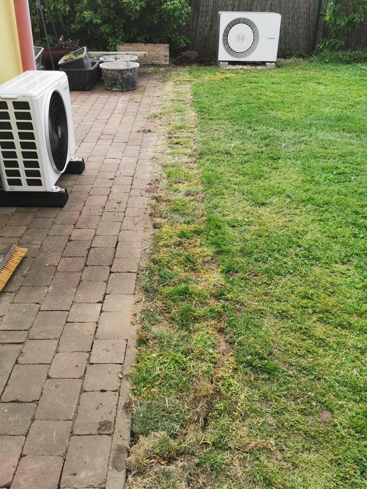 Bosch Wärmepumpen Inneneinheit im Keller neben Pufferspeicher, mit gedämmten Rohrleitungen und Anzeige.