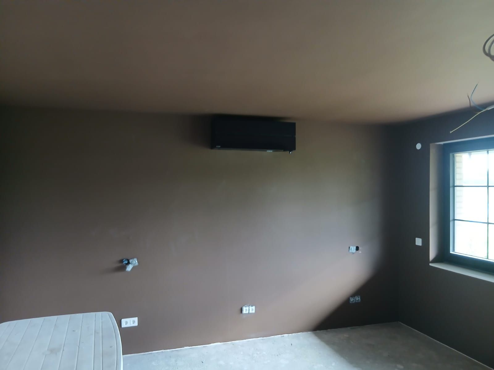 Innenanlage einer Bosch Wärmepumpe integriert an eine Want eines noch fertig zu stellenden Wohnzimmers