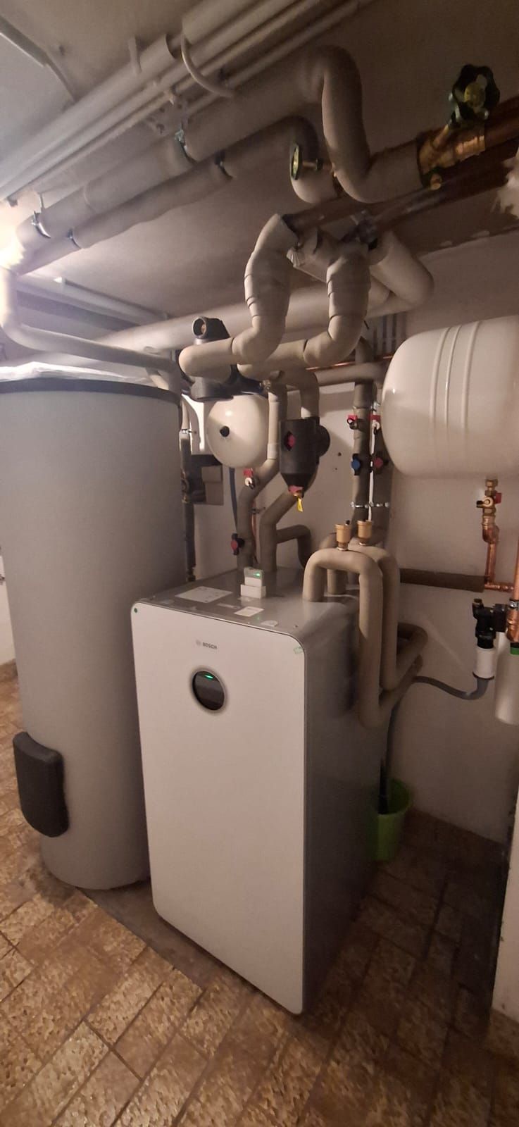 Die Inneneinheit einer Bosch Klimaanlage angeschlossen am Keller mit gut strunkturierten Rohren.