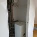 Kleiner Technikraum mit Wärmespeicher, Verrohrung, Ausdehnungsgefäß und Kupferleitungen.