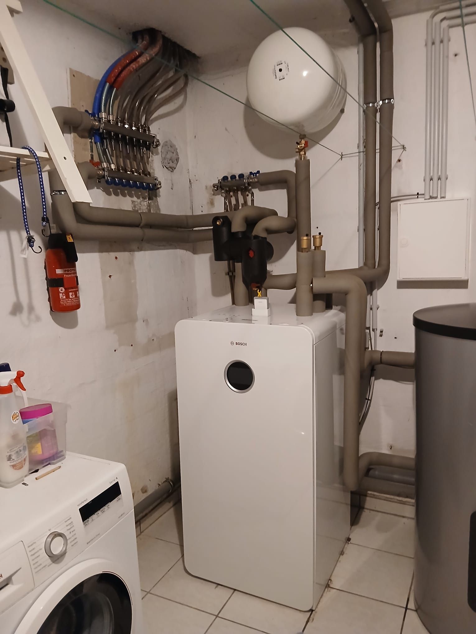 Innenanlage einer Bosch Wärmepumpe mit gut strukturierter Rohrleitung in einem Keller.
