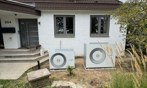 Außenansicht Einfamilienhaus mit zwei installierten Bosch Wärmepumpen im Vorgarten.