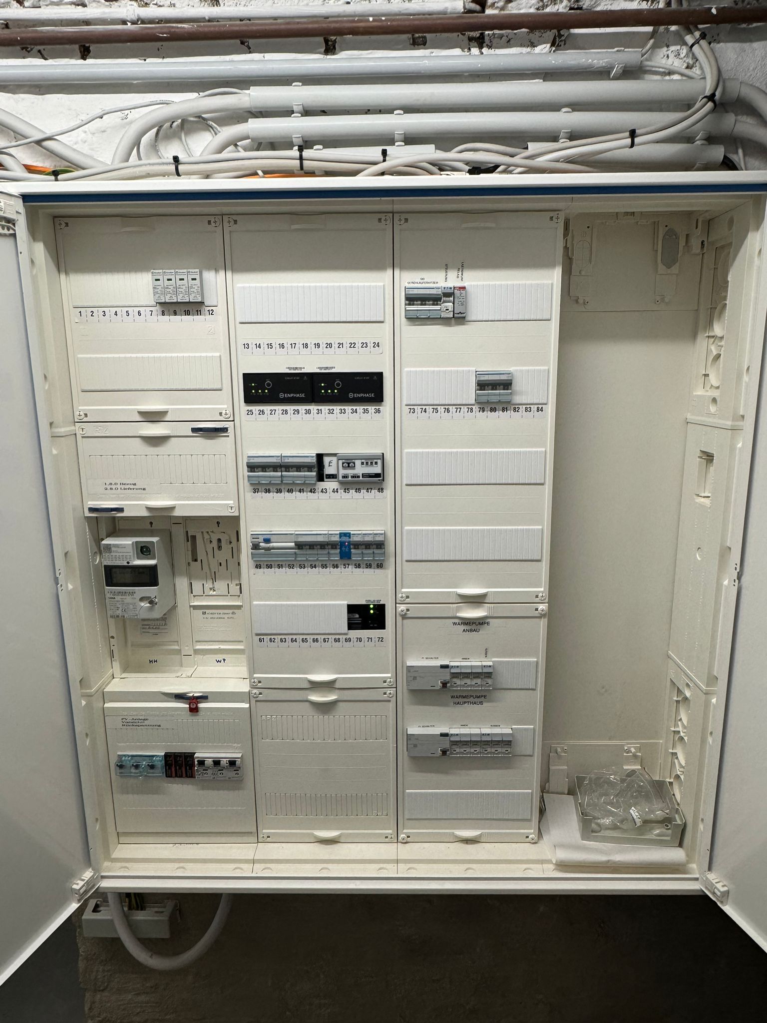Geöffneter Sicherungskasten mit beschrifteten Stromkreisen für Wärmepumpe und Hausanschlüsse.